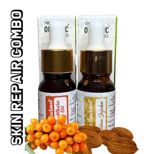 A glass dropper bottle of " SEA BUCKTHORN OIL & GOLDEN JOJOBA OIL" sits on a white background next to a small, rectangular carboard ox. text on the bottle includes " THE ORGANIC SUPPLIES," and the label of "SKIN REPAIR COMBO". some organ Seabuckthorn berries and jojoba seeds 