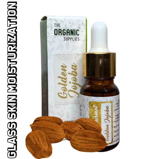 An image showcasing a glass bottle of 'Golden Jojoba Oil' from the brand 'The Organic Supplies.' The bottle is surrounded by golden jojoba seeds, emphasizing the natural origin of the product. and  The packaging box, along  the label 'Glass Skin Moisturization,' indicating the intended use.
